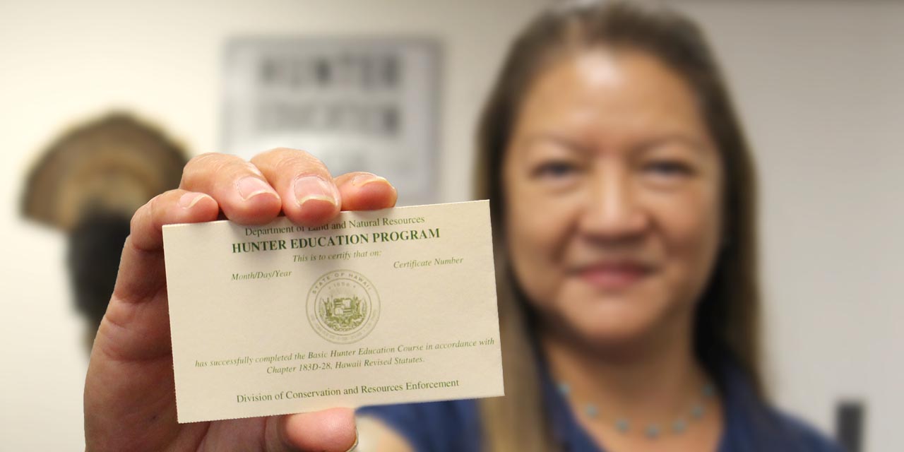 Hunter Education staff holding a certification card.